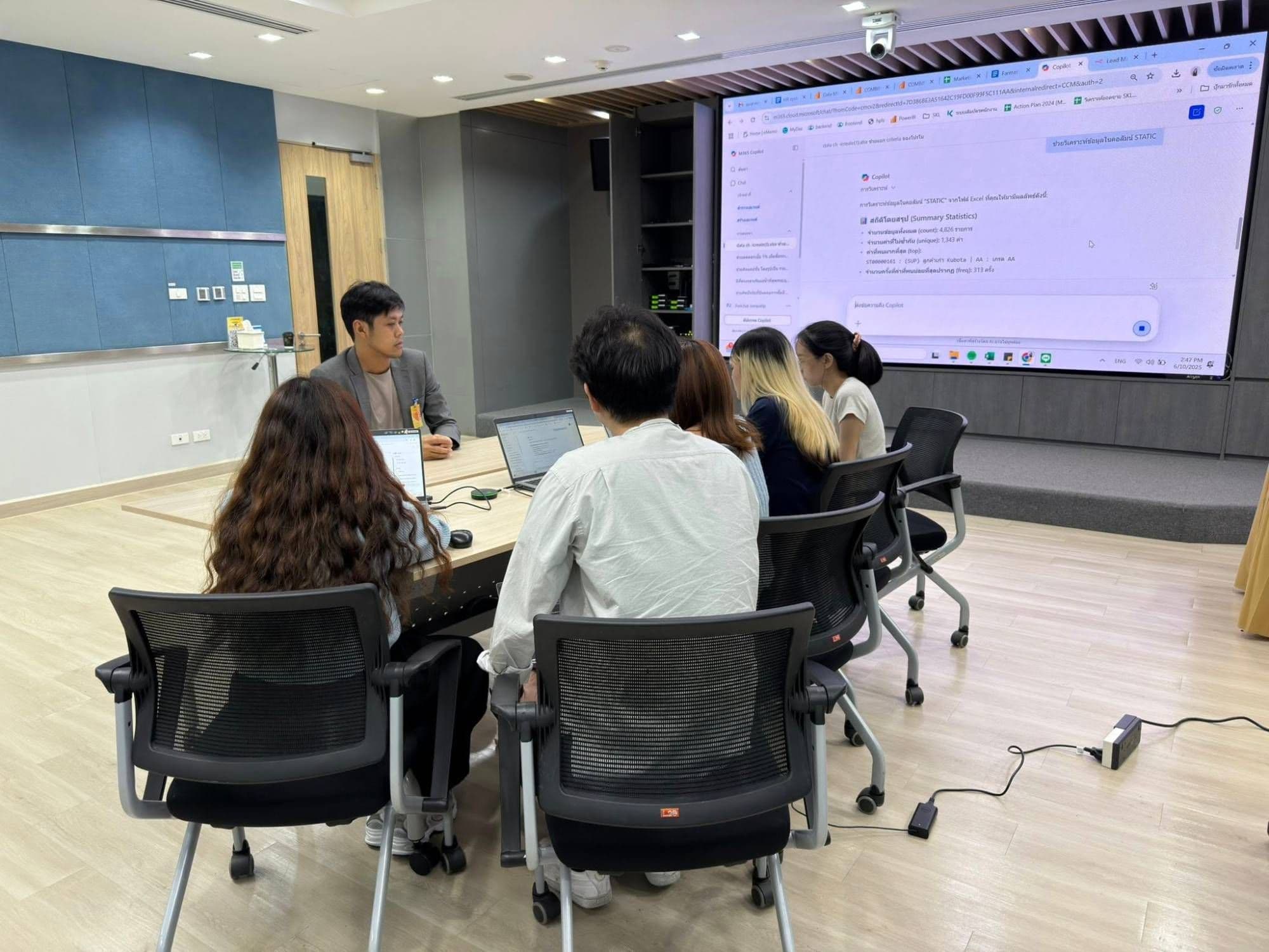 เซสชันให้คำปรึกษา AI ที่ Siam Kubota Leasing ผู้เข้าร่วมดูการใช้ Microsoft 365 Copilot วิเคราะห์ข้อมูลบนจอ
