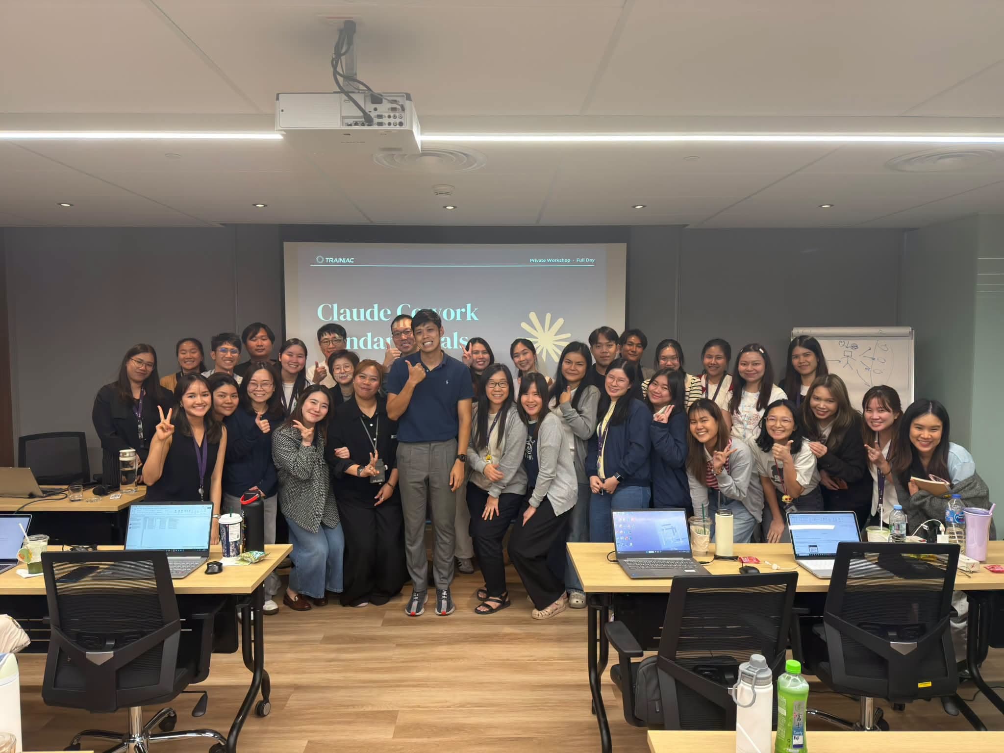 ผู้เข้าอบรม Claude Cowork Advanced Level ของธนาคารเกียรตินาคินภัทร ถ่ายภาพหมู่กับผู้สอน TRAINIAC หน้าสไลด์ Claude Cowork